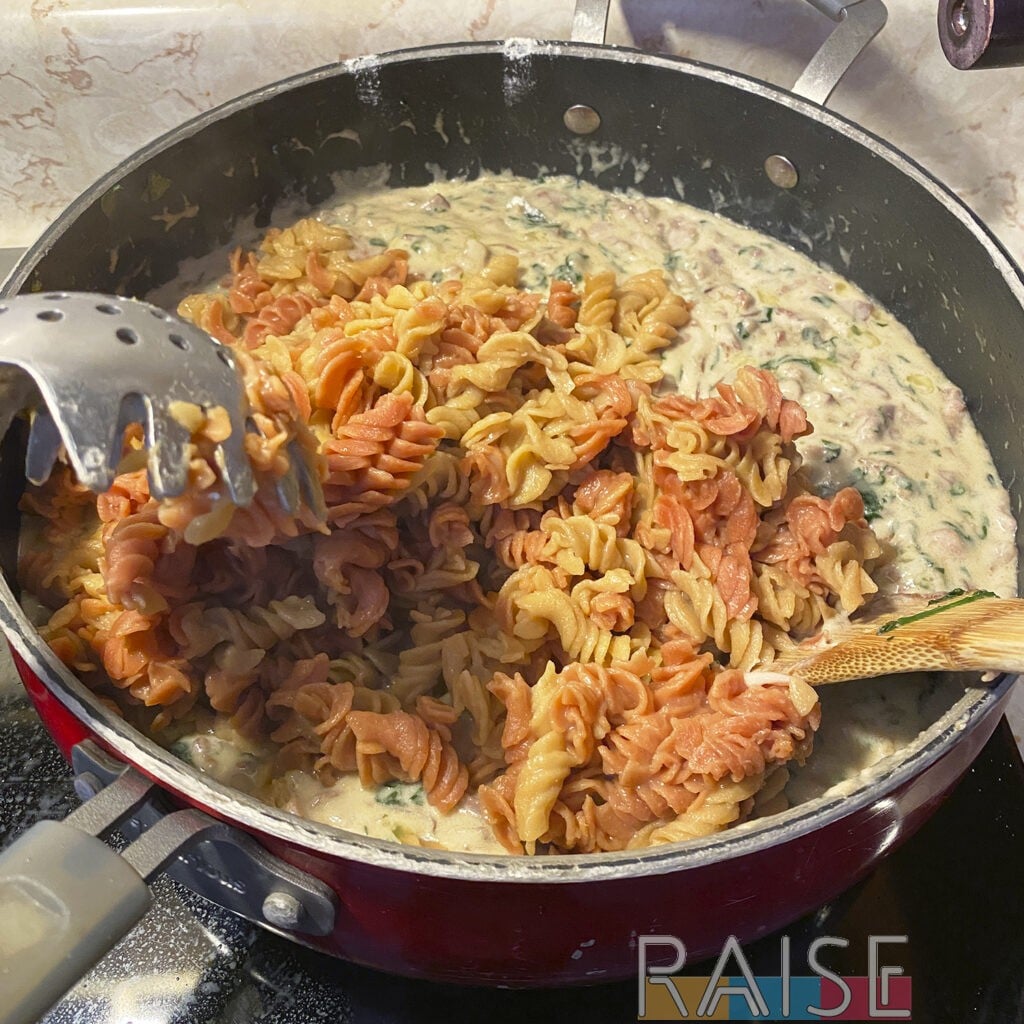 Adding Cooked Pasta to Honey Mustard Bacon Pasta Sauce by The Allergy Chef